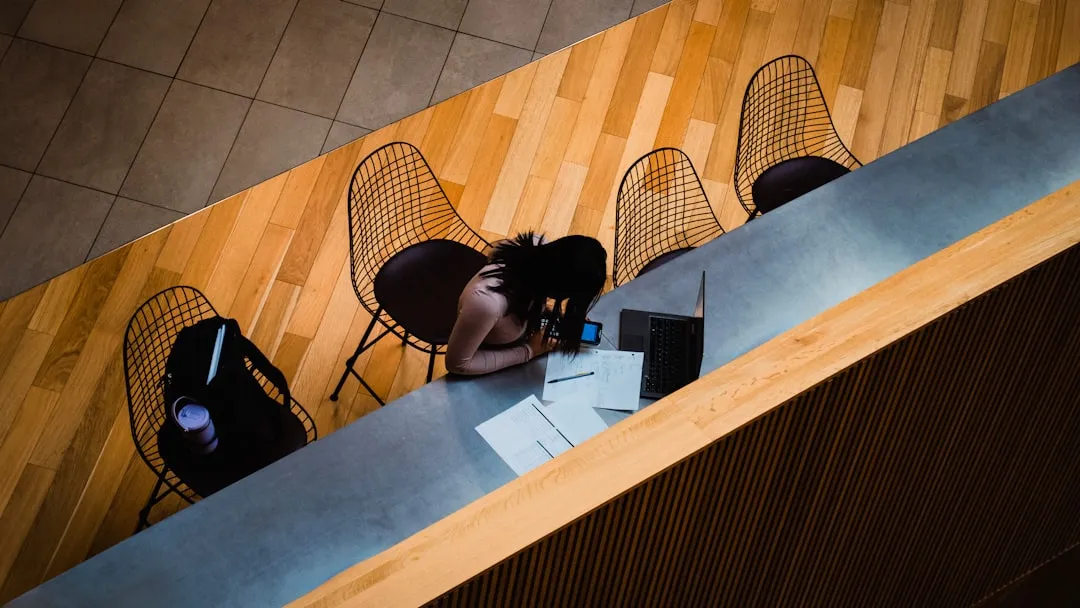 Professional reviewing business financial documents at desk with warm lighting