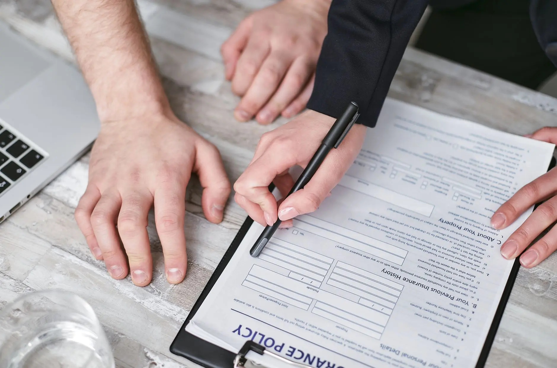 Insurance policy documents spread across a professional desk for review