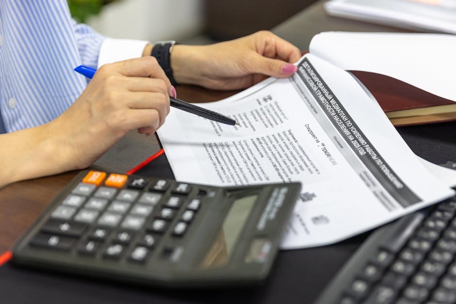 Financial spreadsheet with calculator and business valuation documents on a desk