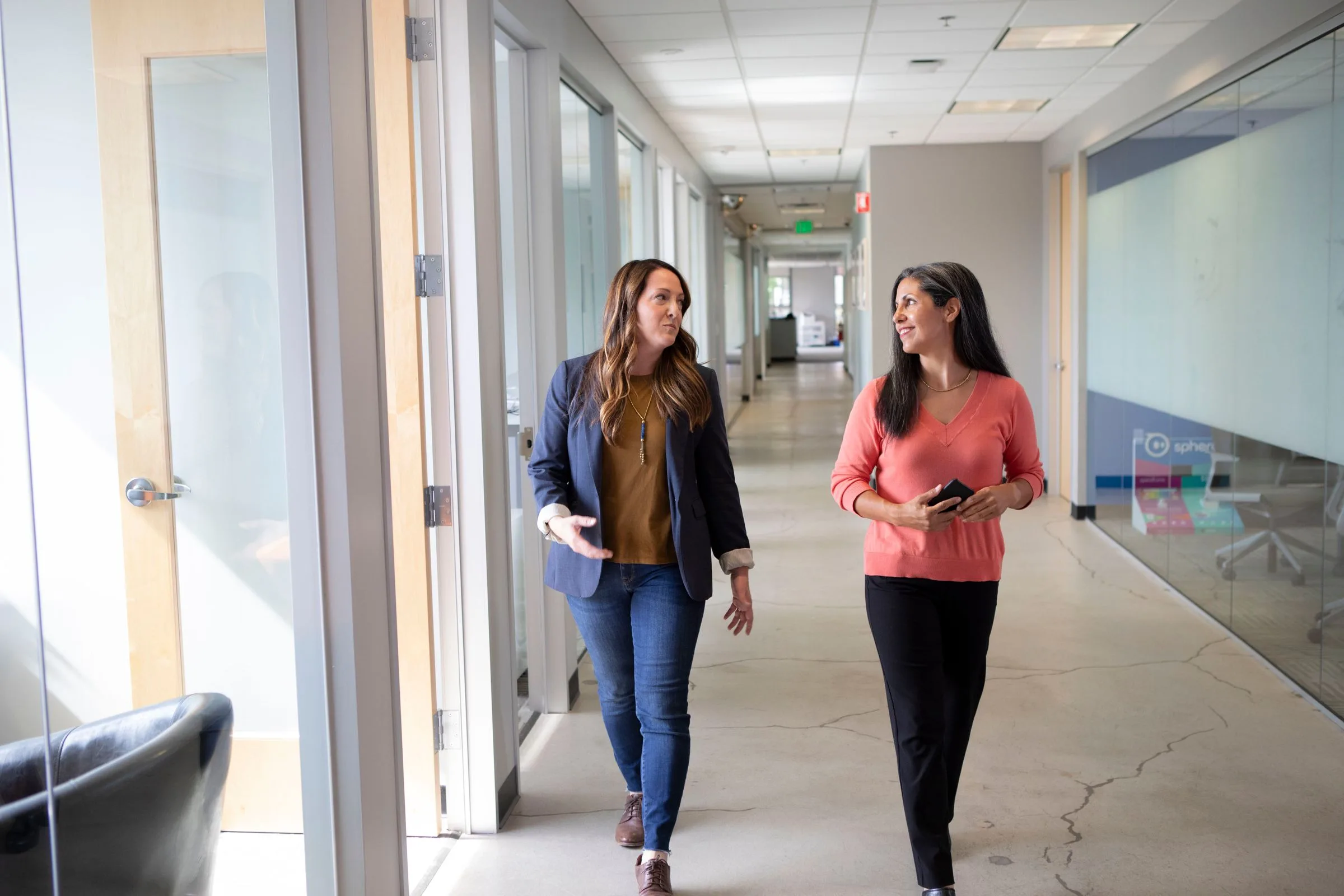 Professionals having an informal business conversation in a modern corridor setting