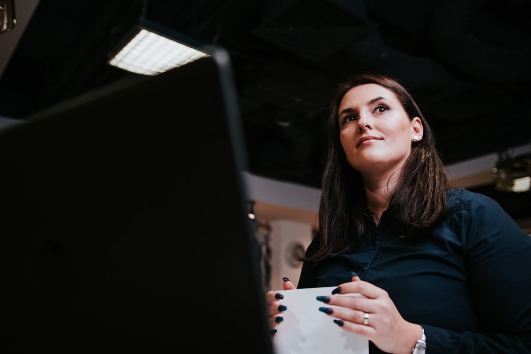 Professional at a desk reviewing paperwork and laptop